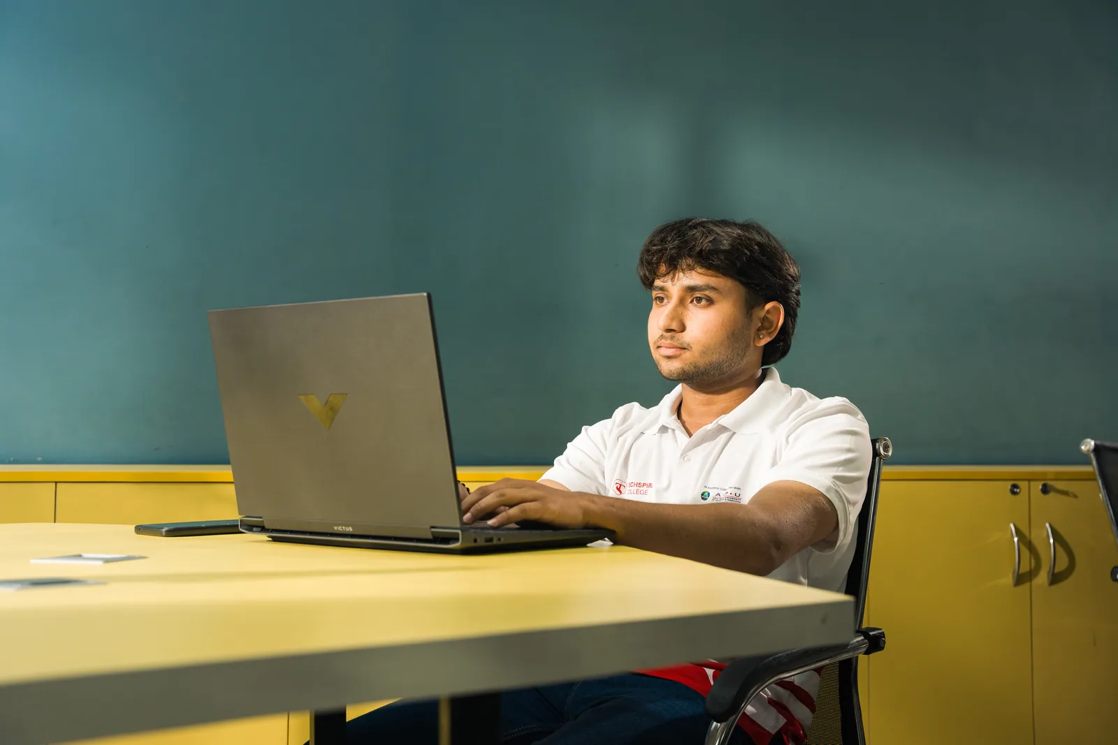 Techspire student using a laptop inside a classroom